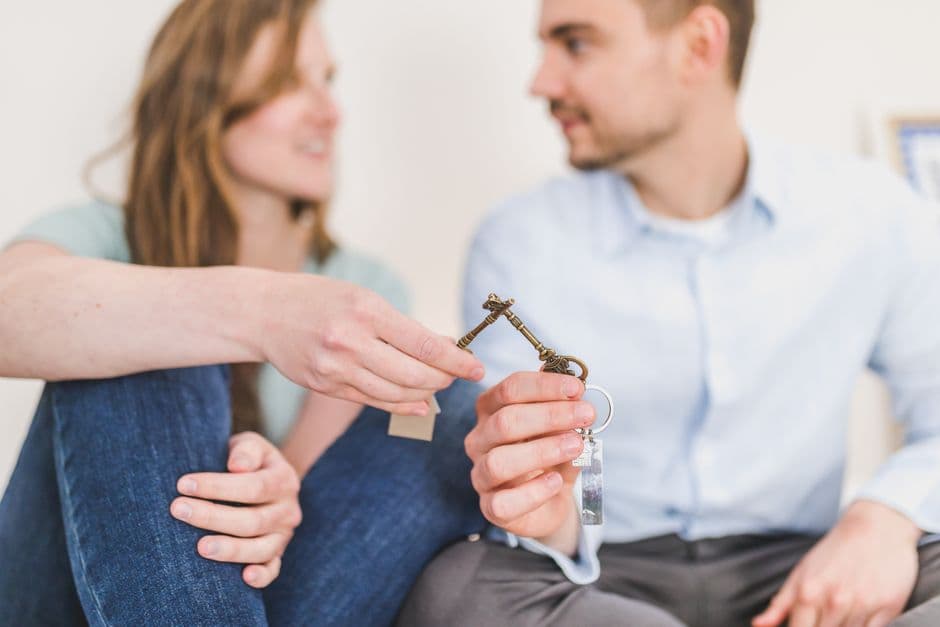 An estate agent handing over a set of house keys to a couple